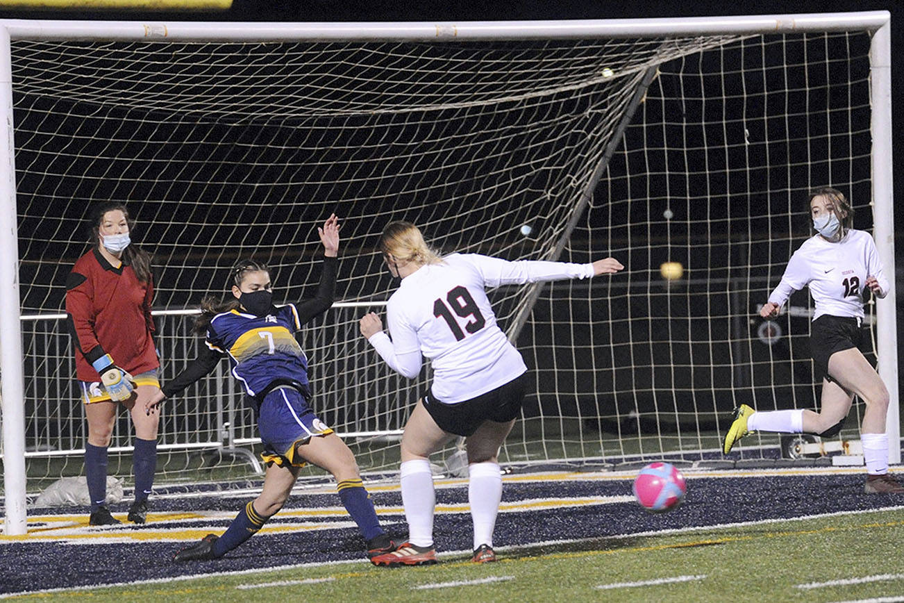 Forks' Candida-Rose Sandoval, second from left, clears the ball away from the Spartans' net between Ocosta players while Forks goalkeeper Katelynn Wallerstedt looks on. (Lonnie Archibald/for Peninsula Daily News)