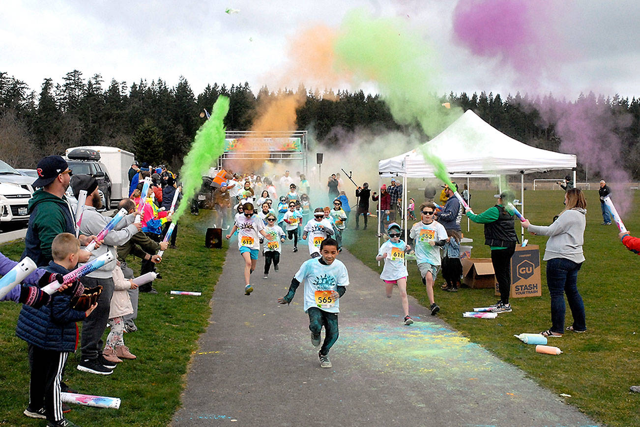Keith Thorpe/Peninsula Daily News
Children run beneath a volley of tempra paint cannons at the start of Saturday's 1k Sun Fun Color Run at Carrie Blake Park, a featured event of the inaugural Sequim Sunshine Festival. The two-day fete, a celebration of Sequim's "sunny" reputation, featured a wide variety of events, displays, performances and activities.
