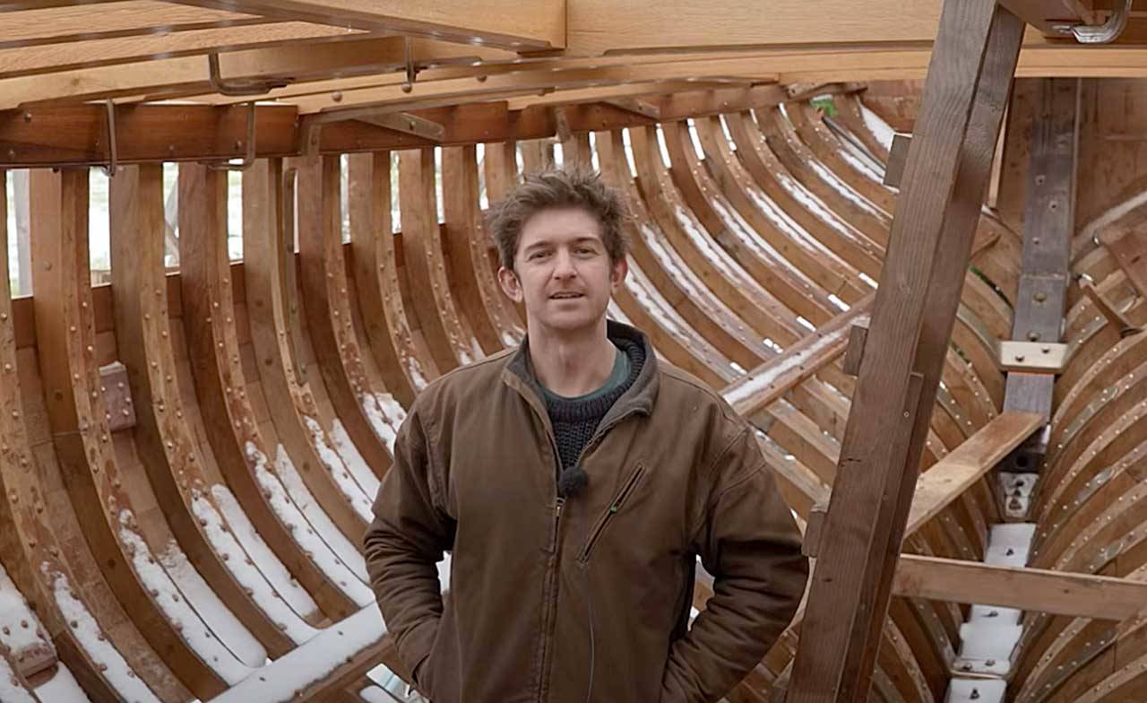 Leo Goolden stands in the wooden hull of Tally Ho, a 1910 cutter he is restoring in the Sequim area. Goolden posted a YouTube video Sunday discussing issues he’s had with a neighbor and Clallam County’s Department of Community Development. (Sampson Boat Co. via YouTube)