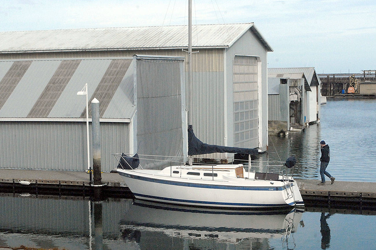 A boat sits moored next to several boathouses at Port Angeles Boat Haven on Thursday. Port of Port Angeles commissioners are suggesting replacing boat houses with floating homes. (Keith Thorpe/Peninsula Daily News)