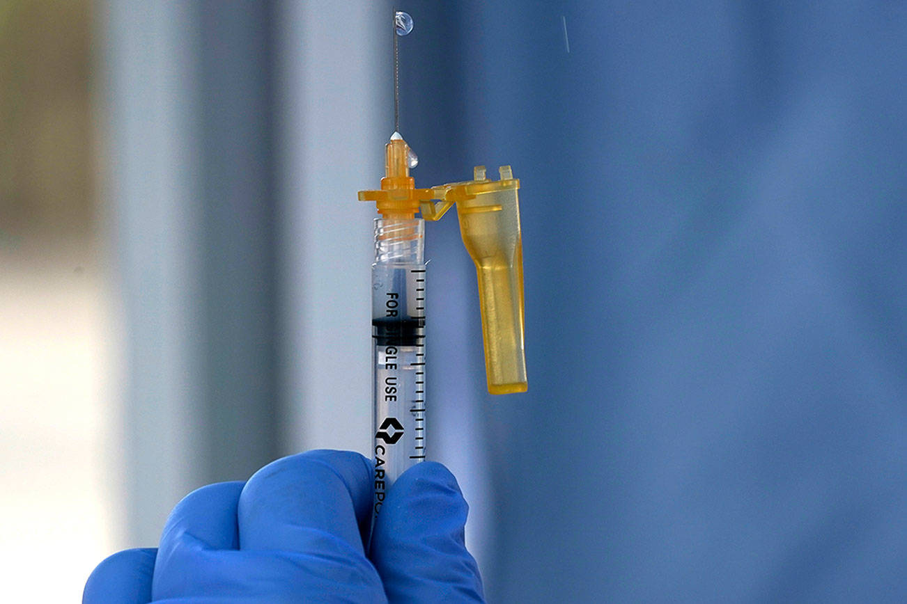 A syringe of the Moderna COVID-19 vaccine is shown Thursday, March 4, 2021, at a drive-up mass vaccination site in Puyallup, Wash., south of Seattle. Officials said they expected to deliver approximately 2500 second doses of the Moderna COVID-19 vaccine at the site Thursday. (AP Photo/Ted S. Warren)