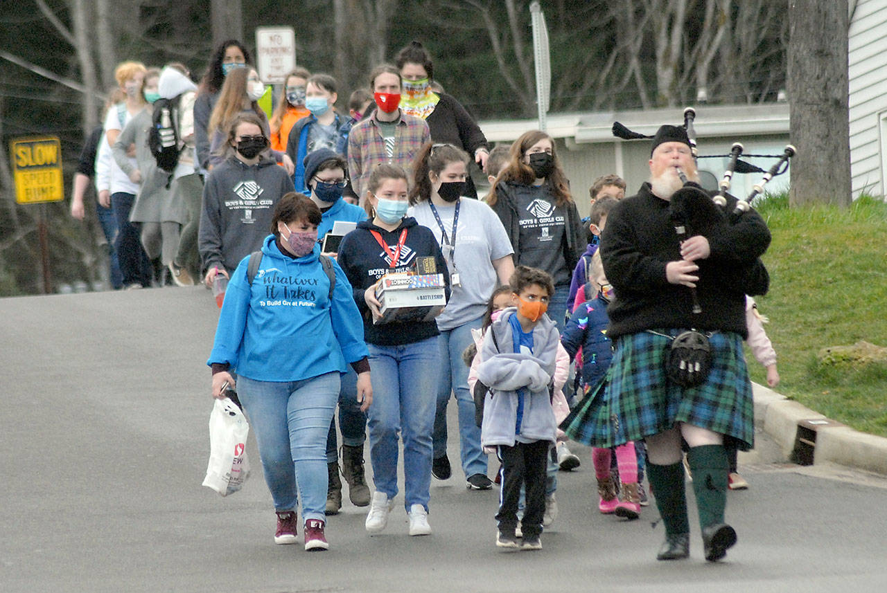 Bagpiper Erik Evans of Port Angeles, right, leads children and staff members down Francis Street from the old clubhouse of the Port Angeles Unit of the Boys & Girls Club to the new Turner Clubhouse on its first day of occupancy on Friday. (Keith Thorpe/Peninsula Daily News)