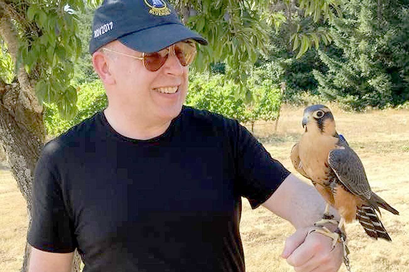 During a summer visit to the Tanager Vineyard in Oregon, Port Angeles Symphony conductor and music director Jonathan Pasternack marvels at an Aplomado falcon. A weekend stay at the Willamette Valley winery where these falcons work is among the items up for bid in the symphony’s “Applause!” Auction this week. (Photo courtesy of Port Angeles Symphony Orchestra)
