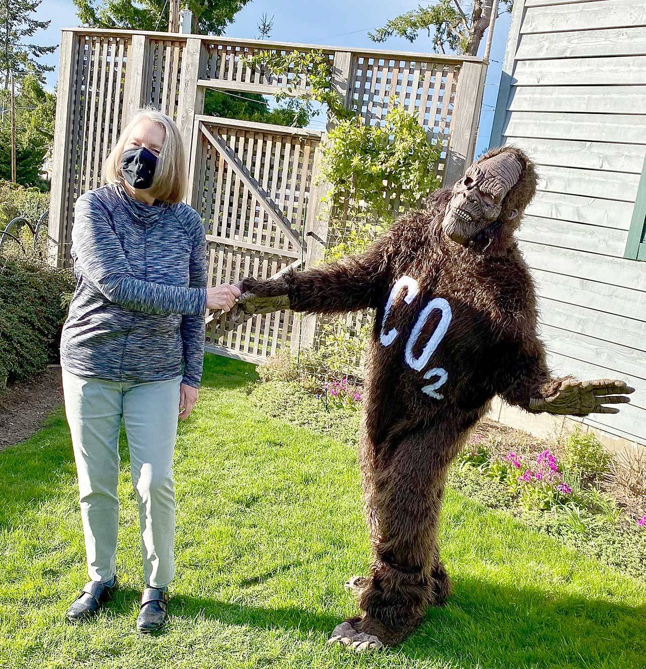 Carol Cummins of Port Townsend, winner of the Taming Bigfoot 2021 contest to reduce the carbon footprint in Jefferson County, receives congratulations from Bigfoot, otherwise known as Polly Lyle of Port Townsend. (Photo courtesy of Polly Lyle)
