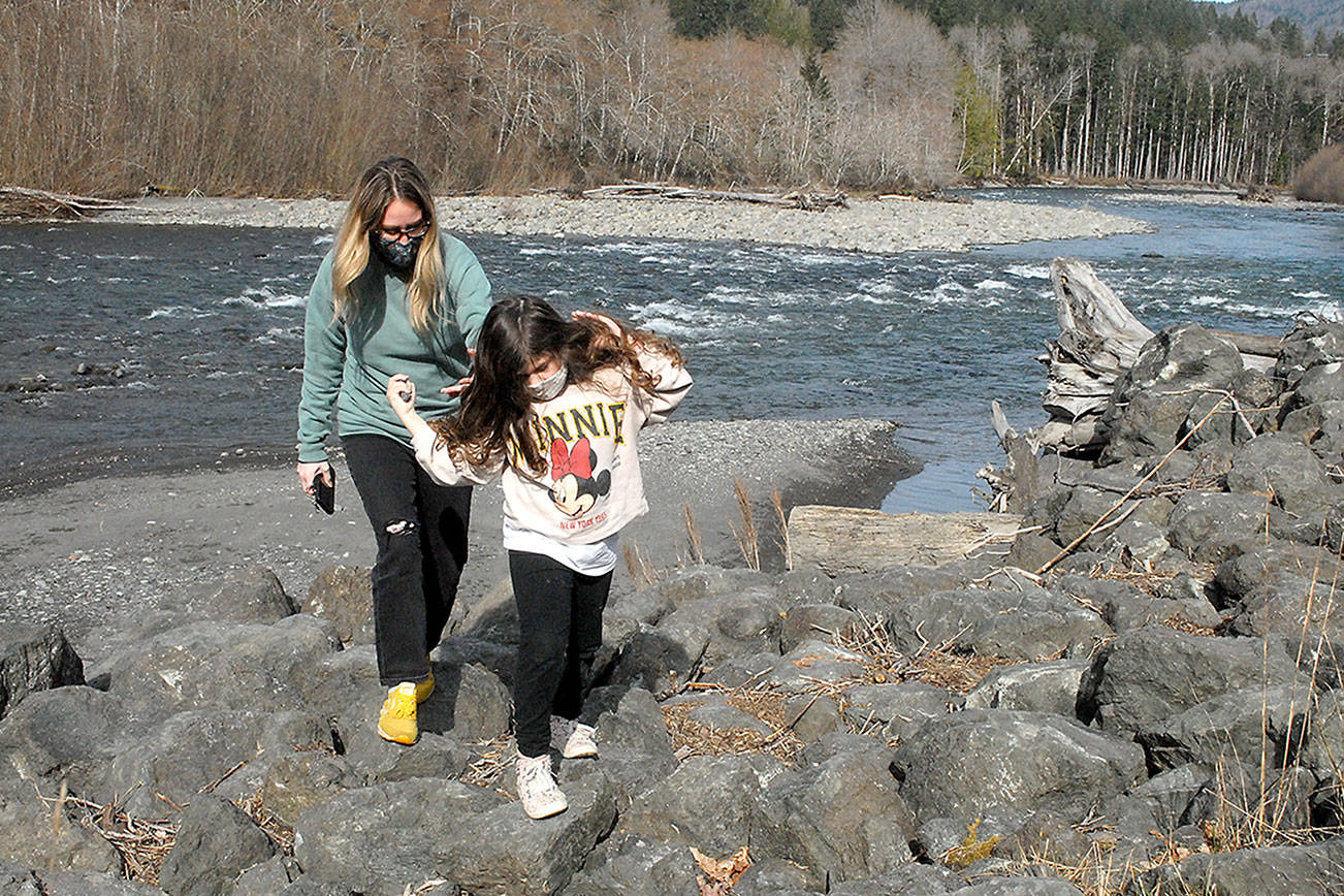 Rebecca Eller and her daughter, Bailey, 6, both of Fort Worth, Texas, pick their way through the rock along the bank of the Elwha River in Olympic National Park west of Port Angeles on Tuesday. They were returning from an excursion along the river’s edge. (Keith Thorpe/Peninsula Daily News)