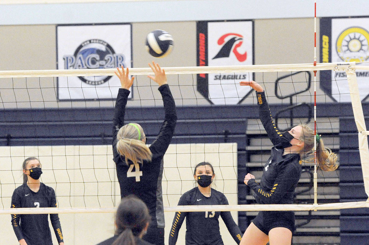 Napavine’s Grace Gall (4) attempts to block a hit by Forks’ Katie Wood on Wednesday evening in Forks, where the Tigers defeated the Spartans 3-0 in the Class 2B Southwest District Volleyball Tournament. (Lonnie Archibald/for Peninsula Daily News)