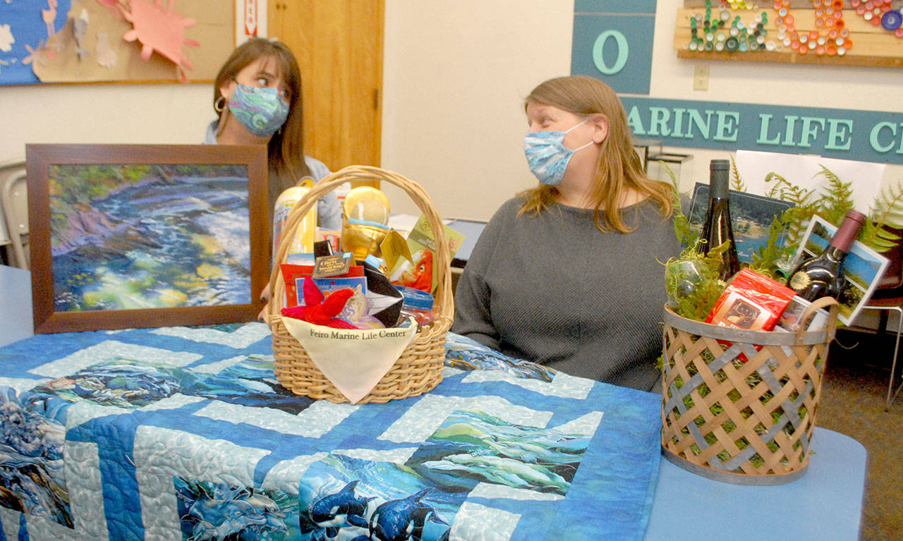 <strong>Keith Thorpe</strong>/Peninsula Daily News
 Feiro Marine Life Center Development Director Linty Hopie, left, and Executive Director Melissa Williams sit with some of the auction items to be sold at the centers Making Waves 2021: Resilience online fundraising event.