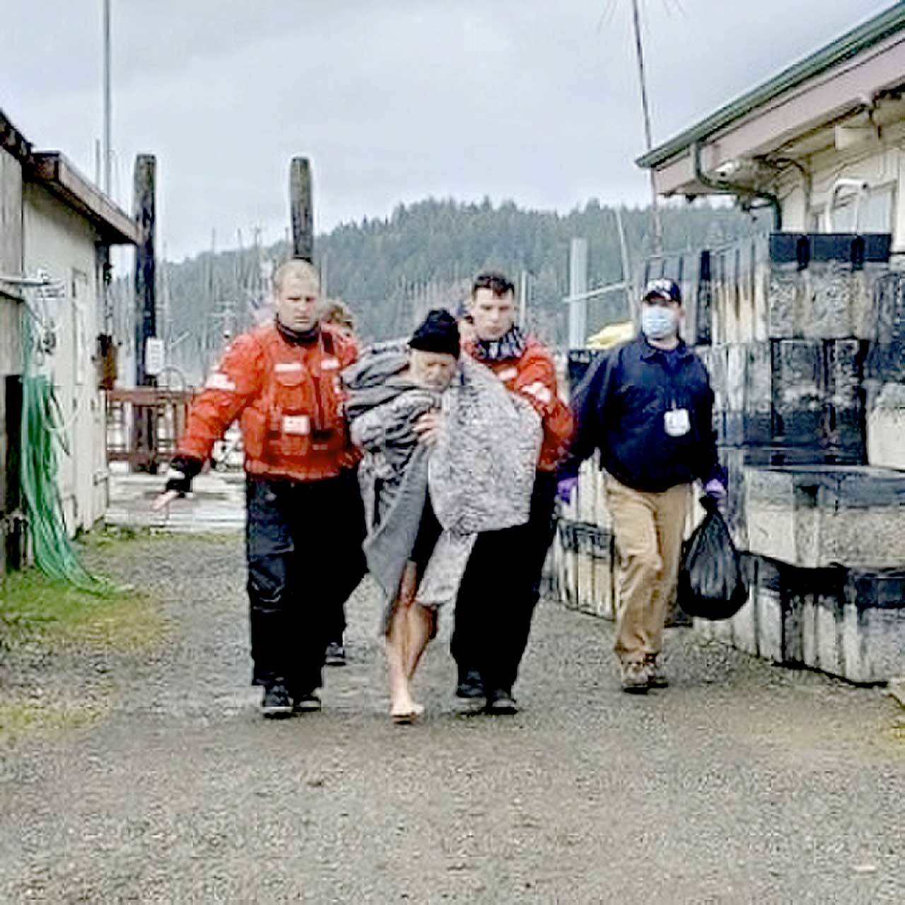 Members from Coast Guard Station Quillayute River help a man to an awaiting ambulance after the vessel he was in sank on Saturday 5 miles off the coast of La Push. None of the three men were wearing lifejackets. (U.S. Coast Guard photo by Station Quillayute River)