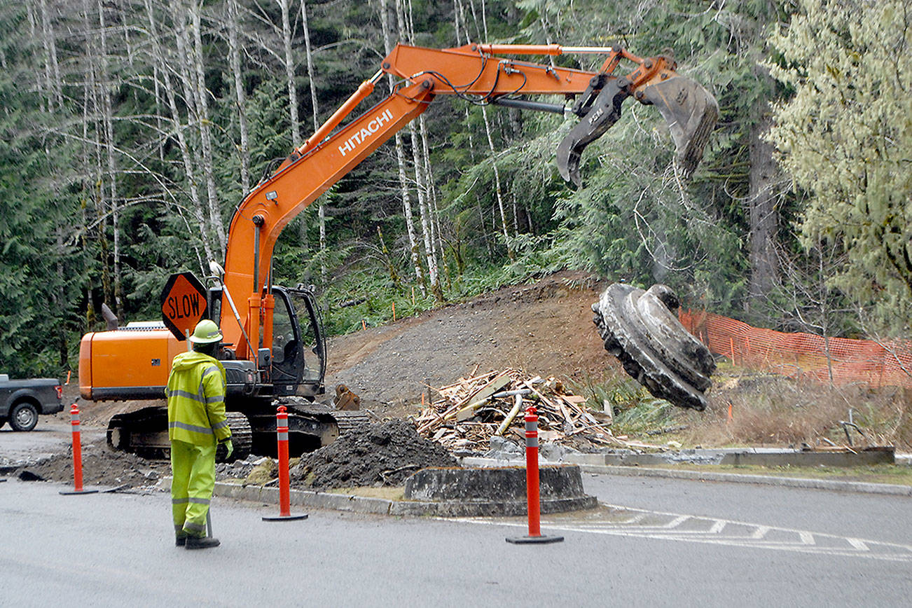 Jim Childs, a traffic control supervisor for Vancouver, Wash.-based Conway Construction Co., watches as an excavator breaks up concrete at the site of the former Heart o’ the Hills entrance station to Olympic National Park on Thursday south of Port Angeles. (Keith Thorpe/Peninsula Daily News)