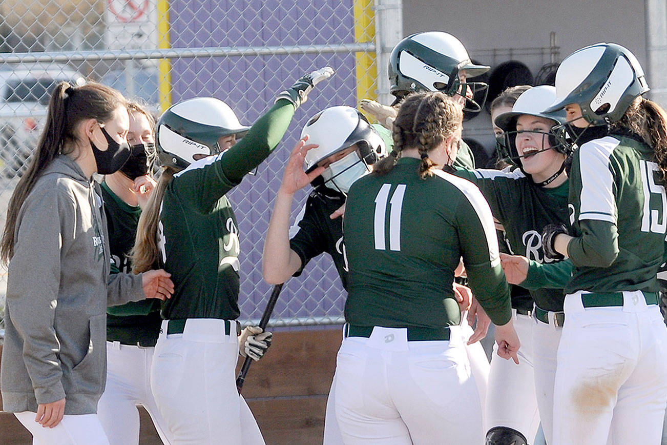 Michael Dashiell/Olympic Peninsula News Group
Port Angeles teammates congratulate Natalie Robinson, center in mask, after her three-run home run in the fifth inning helped the Roughriders beat the Sequim Wolves 11-6.