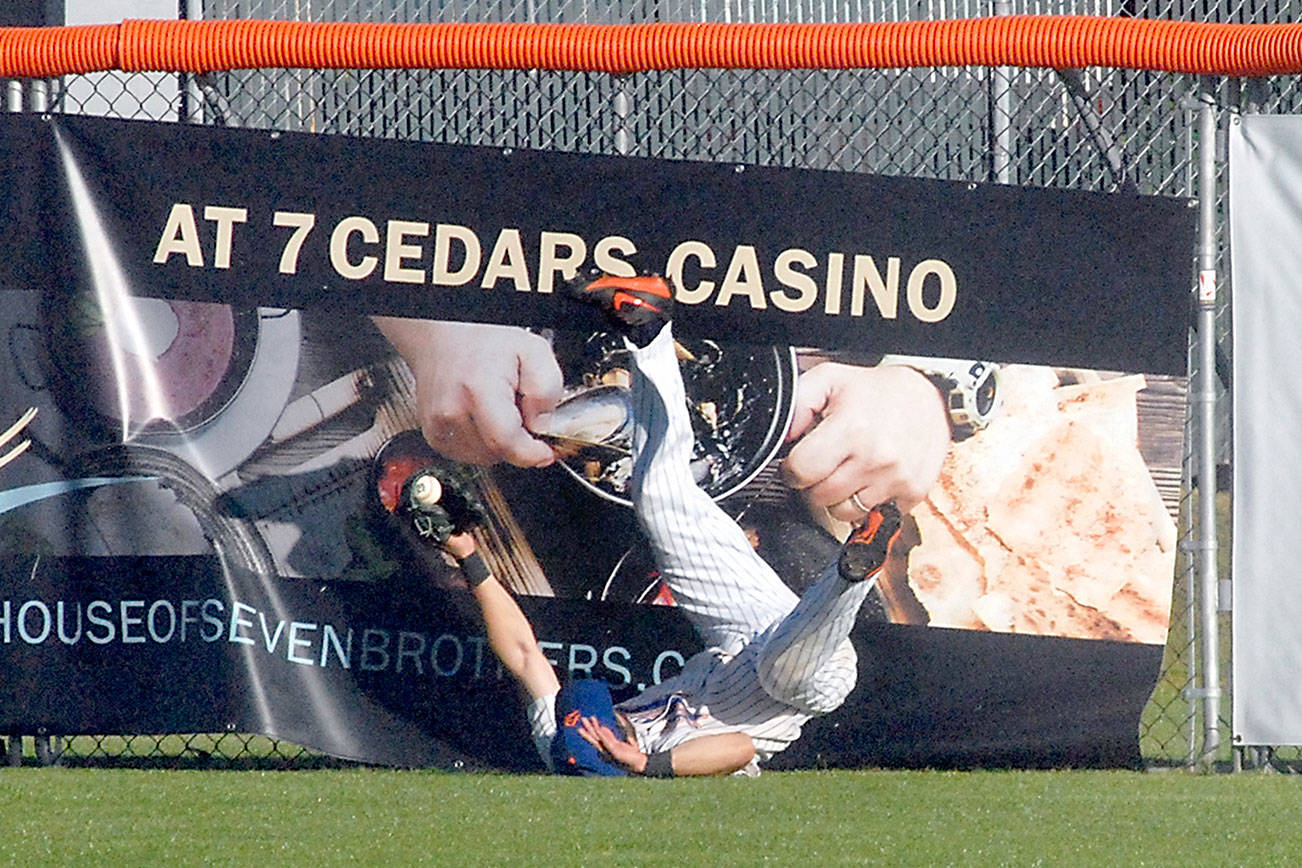 Keith Thorpe/Peninsula Daily News
Lefties centerfielder Ronnie Rust tumbles to the ground after crashing into the fence fielding a long fly ball in the second inning against the Bellingham Bells in June 2019 at Port Angeles Civic Field. The Lefties will begin the 2021 season at home on June 1.