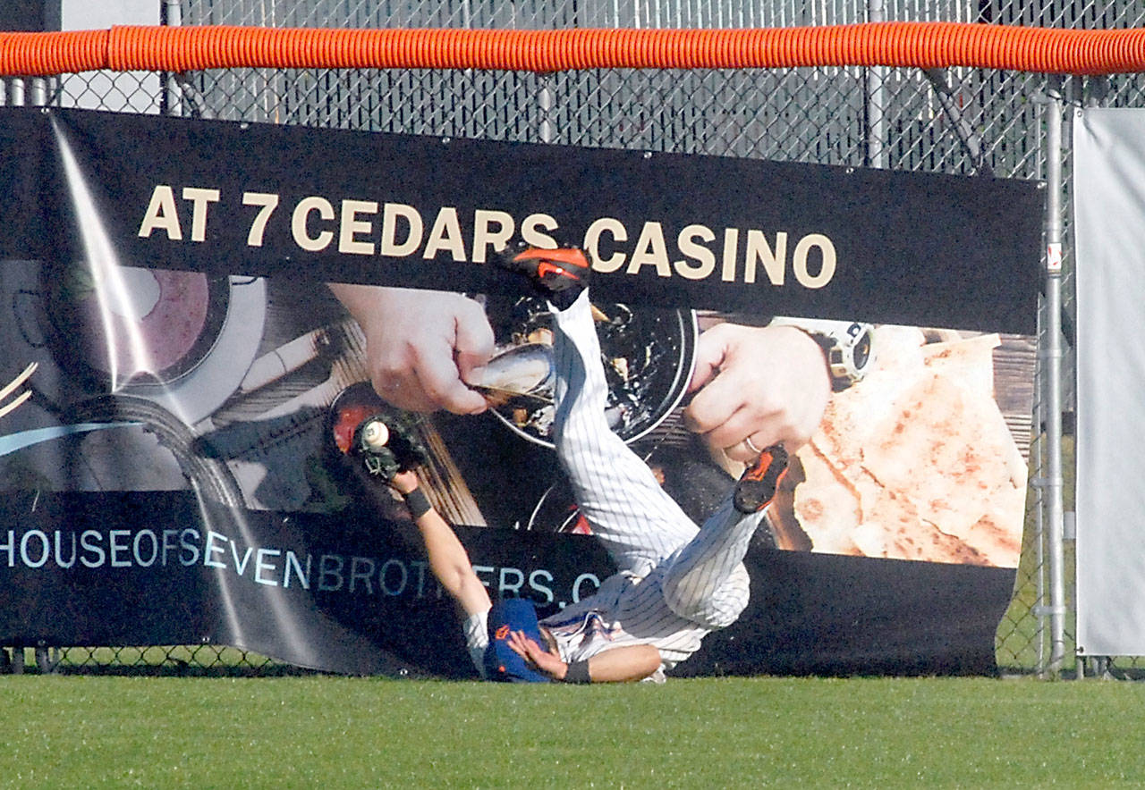 Keith Thorpe/Peninsula Daily News Lefties centerfielder Ronnie Rust tumbles to the ground after crashing into the fence fielding a long fly ball in the second inning against the Bellingham Bells in June 2019 at Port Angeles Civic Field. The Lefties will begin the 2021 season at home on June 1.
Lefties centerfielder Ronnie Rust tumbles to the ground after crashing into the fence fielding a long fly ball in the second inning against the Bellingham Bells in June 2019 at Port Angeles Civic Field. The Lefties will begin the 2021 season at home on June 1. (Keith Thorpe/Peninsula Daily News)