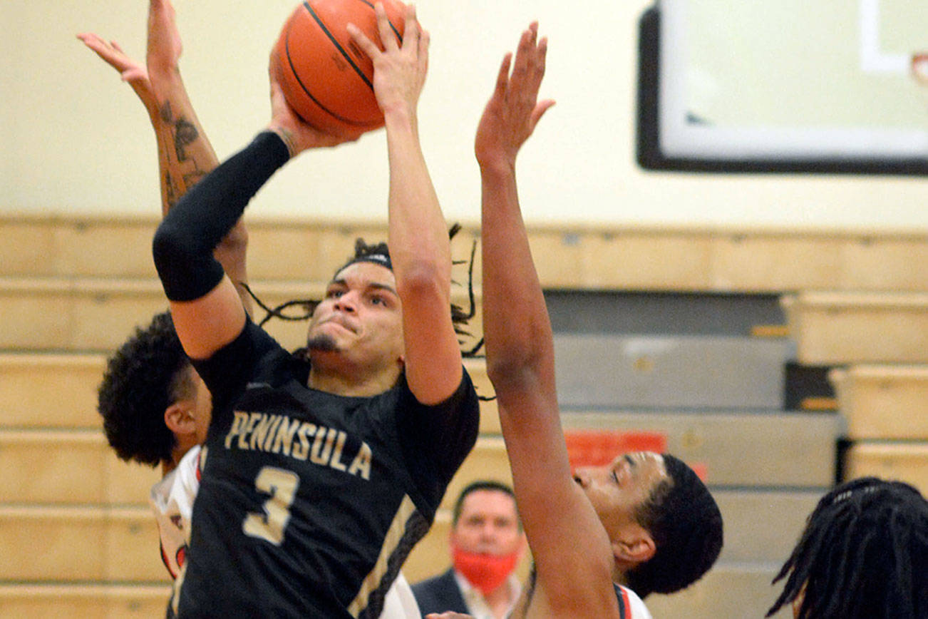 Peninsula’s Jaylin Reed looks to get off a shot while heavily defended by Skagit Valley during the Pirates’ 71-68 OT loss to the Cardinals. (Rick Ross/Peninsula College)