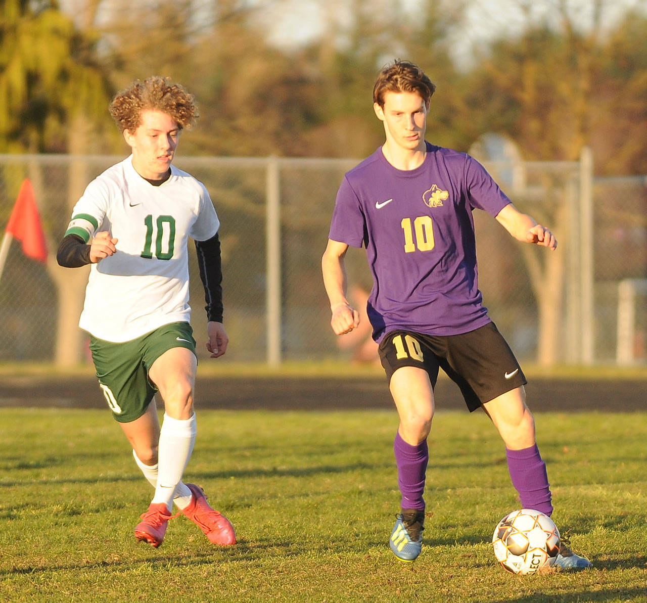 Sequim’s Eli Gish, right, looks for a teammate as Port Angeles’ Damon Gunderson defends in a March 25 match in Sequim. (Michael Dashiell/Olympic Peninsula News Group)