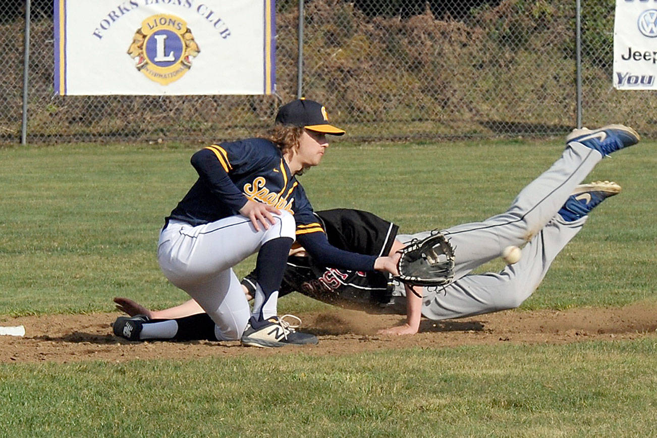 Lonnie Archibald/for Peninsula Daily News
Forks shortstop Logan Olson makes the tag during the first game of the Spartans' doubleheader sweep of Ocosta at Fred Orr Memorial Field in Beaver on Tuesday.