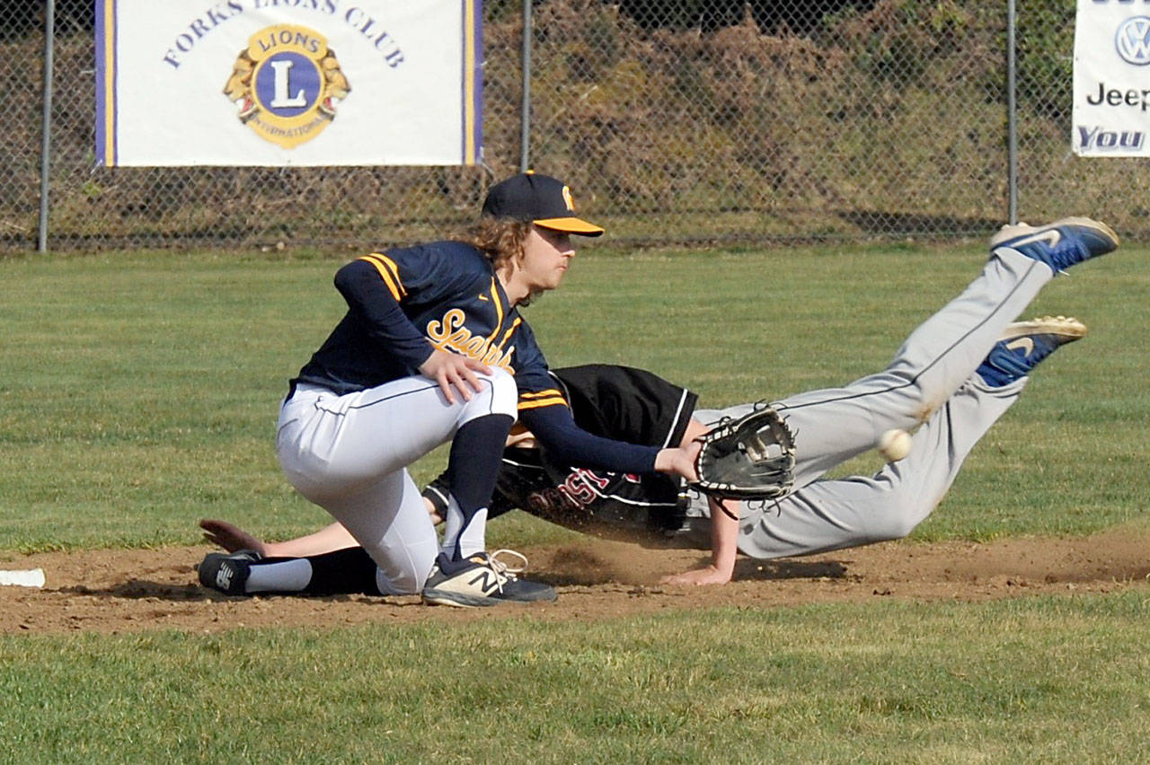 Forks shortstop Logan Olson makes the tag during the first game of the Spartans’ doubleheader sweep of Ocosta at Fred Orr Memorial Field in Beaver on Tuesday. (Lonnie Archibald/for Peninsula Daily News)