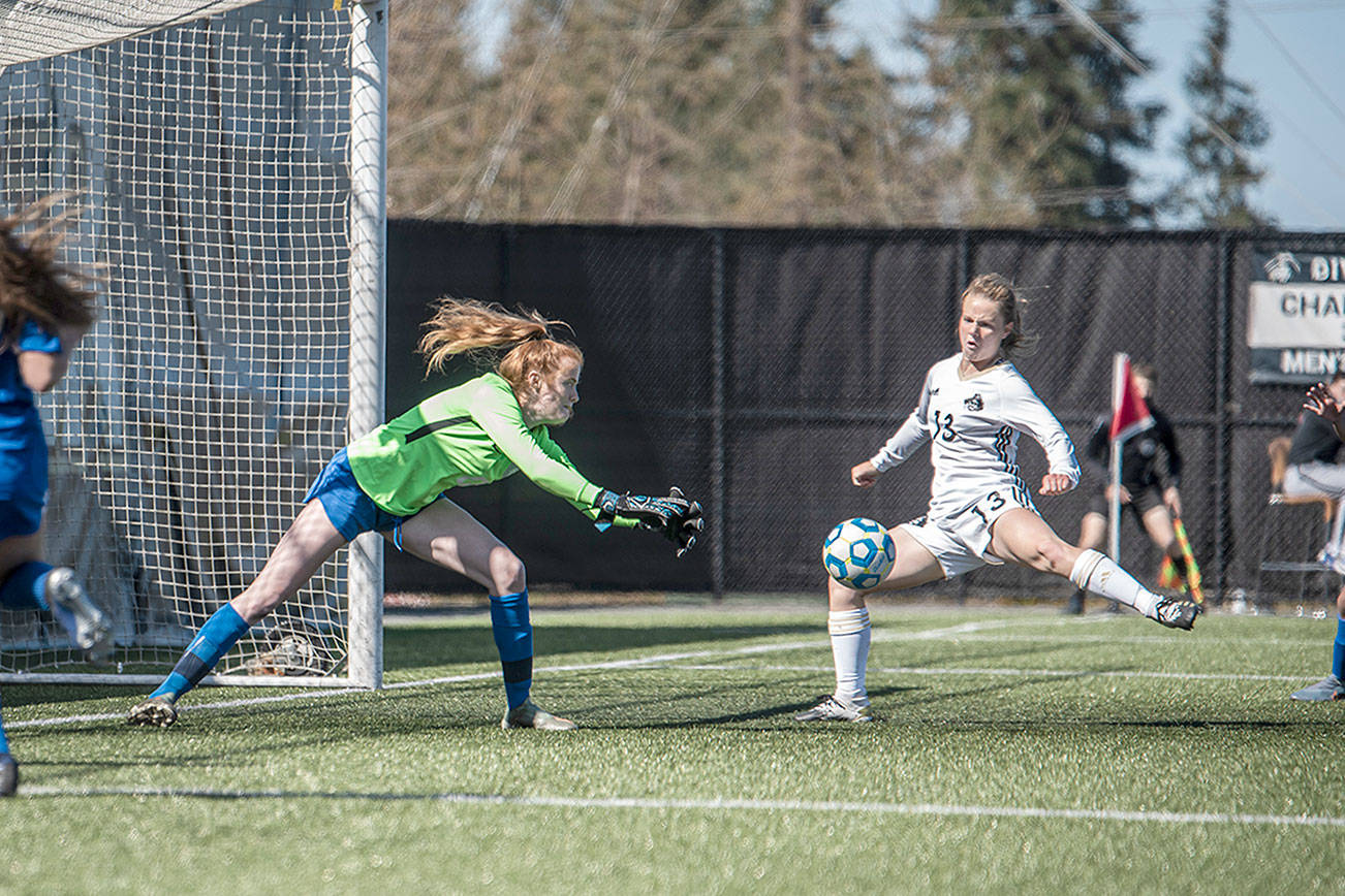 Jesse Major/for Peninsula Daily News
Peninsula's Makenna Warren, right, sweeps her leg onto a perfectly-positioned corner kick from Miya Clark as Edmonds goalkeeper Emily Morandi defends during the Pirates' 3-0 home opener win Monday. Warren scored a goal on the play.