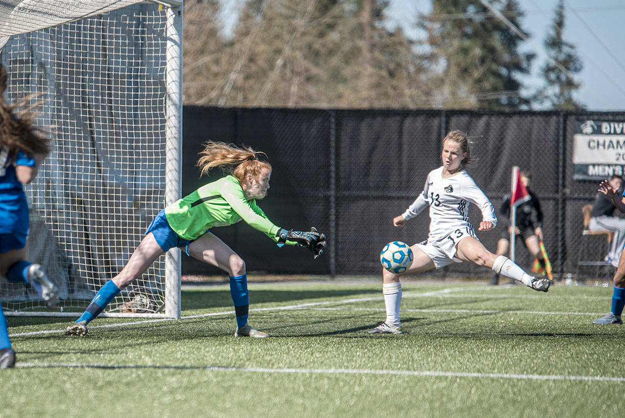 Peninsulas Makenna Warren, right, sweeps her leg onto a perfectly positioned corner kick from Miya Clark as Edmonds goalkeeper Emily Morandi defends during the Pirates 3-0 home opener win Monday. Warren scored a goal on the play. (Jesse Major/for Peninsula Daily News)