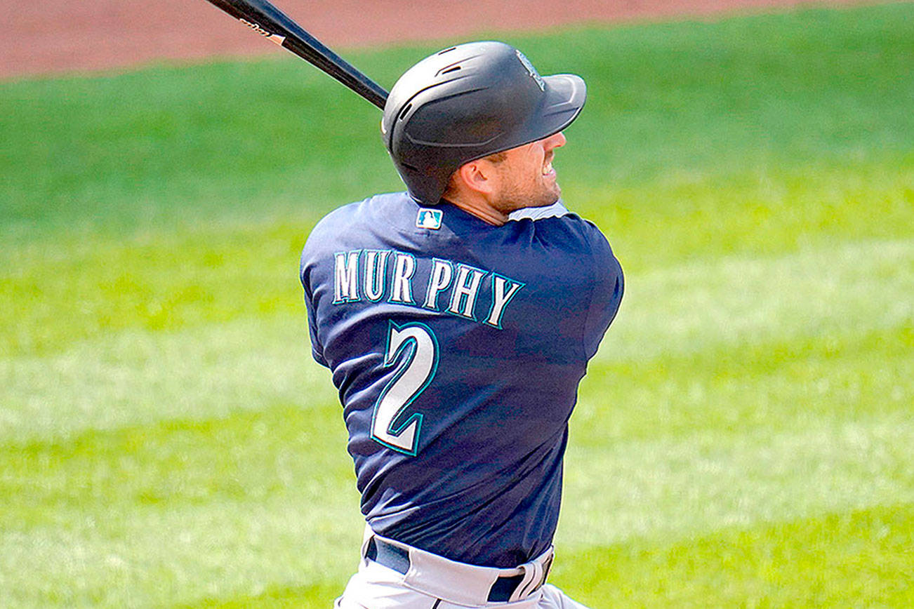 Seattle Mariners' Tom Murphy follows through on a swing while hitting a solo home run off Baltimore Orioles starting pitcher John Means during the second inning of the first game of a baseball doubleheader, Tuesday, April 13, 2021, in Baltimore. (AP Photo/Julio Cortez)
