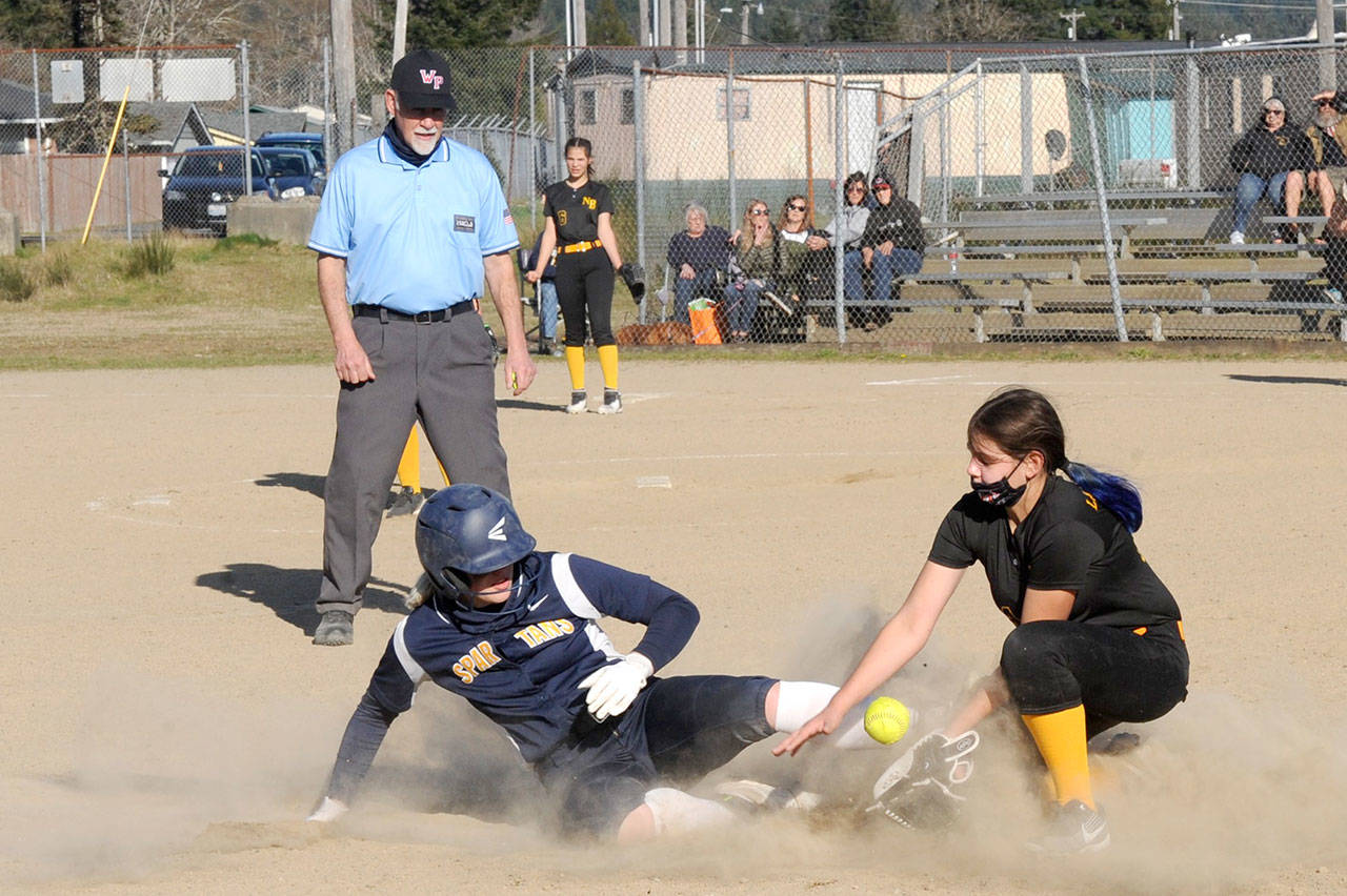 Forks’ Kyra Neel, left, slides safely into third base under the watchful eye of umpire Randy Rooney Tuesday afternoon in the second game of a doubleheader against North Beach at Tillicum Park in Forks. (Lonnie Archibald/for Peninsula Daily News)