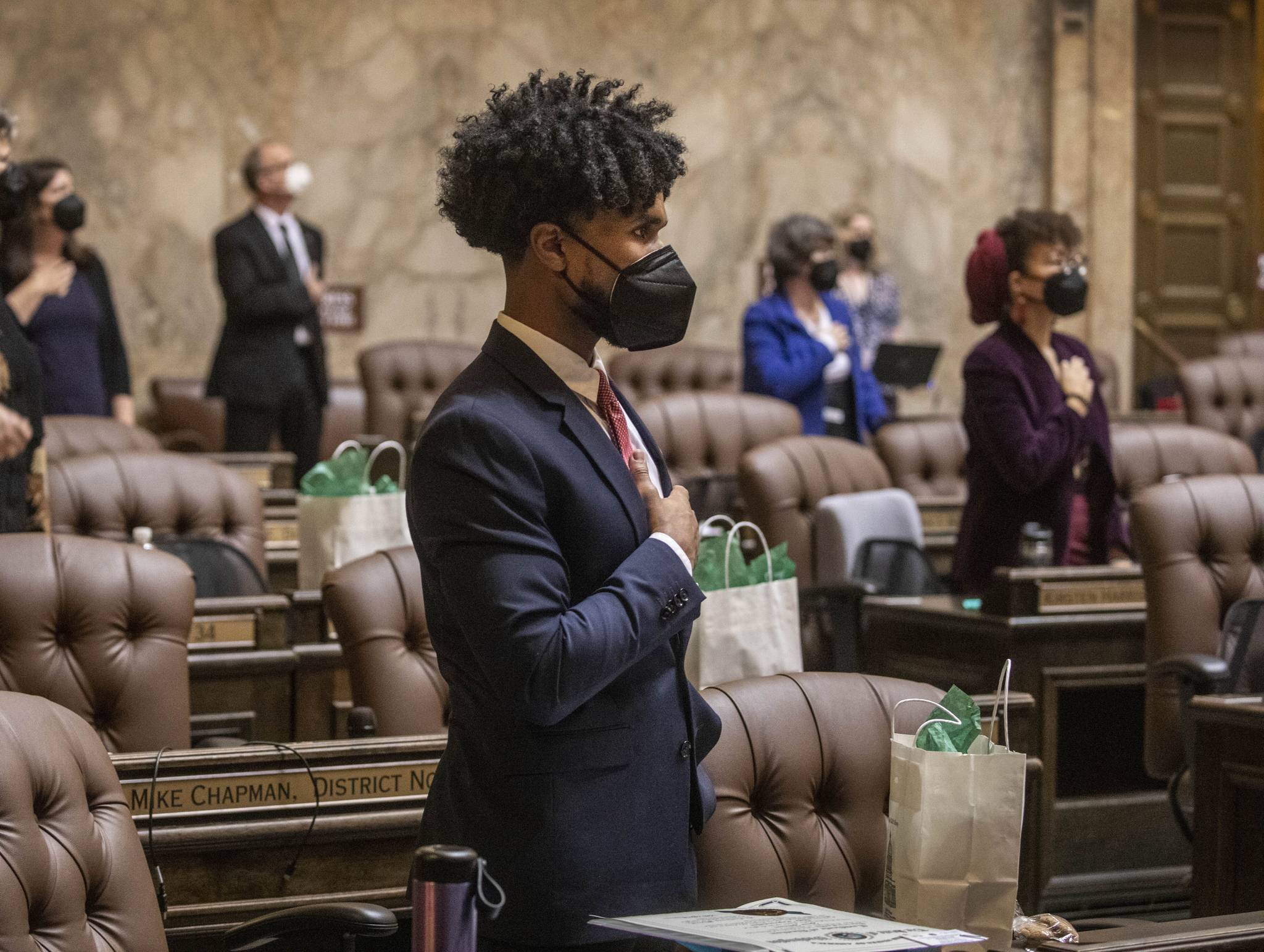 In this file photo from Jan. 11, 2021, state Rep. Jesse Johnson, D-Federal Way, stands with other members at the beginning of the House session during which legislators were spaced at a social distance in Olympia. Johnson hopes to see the Legislature end qualified immunity for police officers, which would allow them to be sued in state court, and to see it authorize community oversight boards that could have input on local policies and receive complaints about officers. (Steve Ringman/The Seattle Times via The Associated Press)