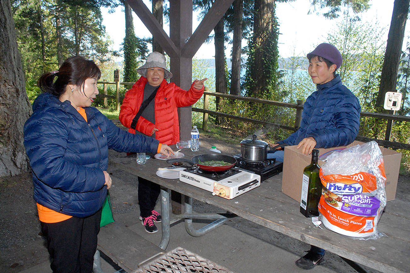 Keith Thorpe/Peninsula Daily News
Young Hanson of Dallas, left, along with Chun Kim and Jennifer Choi, both of Tacoma, prepares lunch at a picnic shelter at Sequim Bay State Park east of Sequim on Thursday. The group was taking advantage of a free day at all Washington state parks in celebration of Earth Day. The next free state parks day will be June 5 to celebrate National Trails Day.