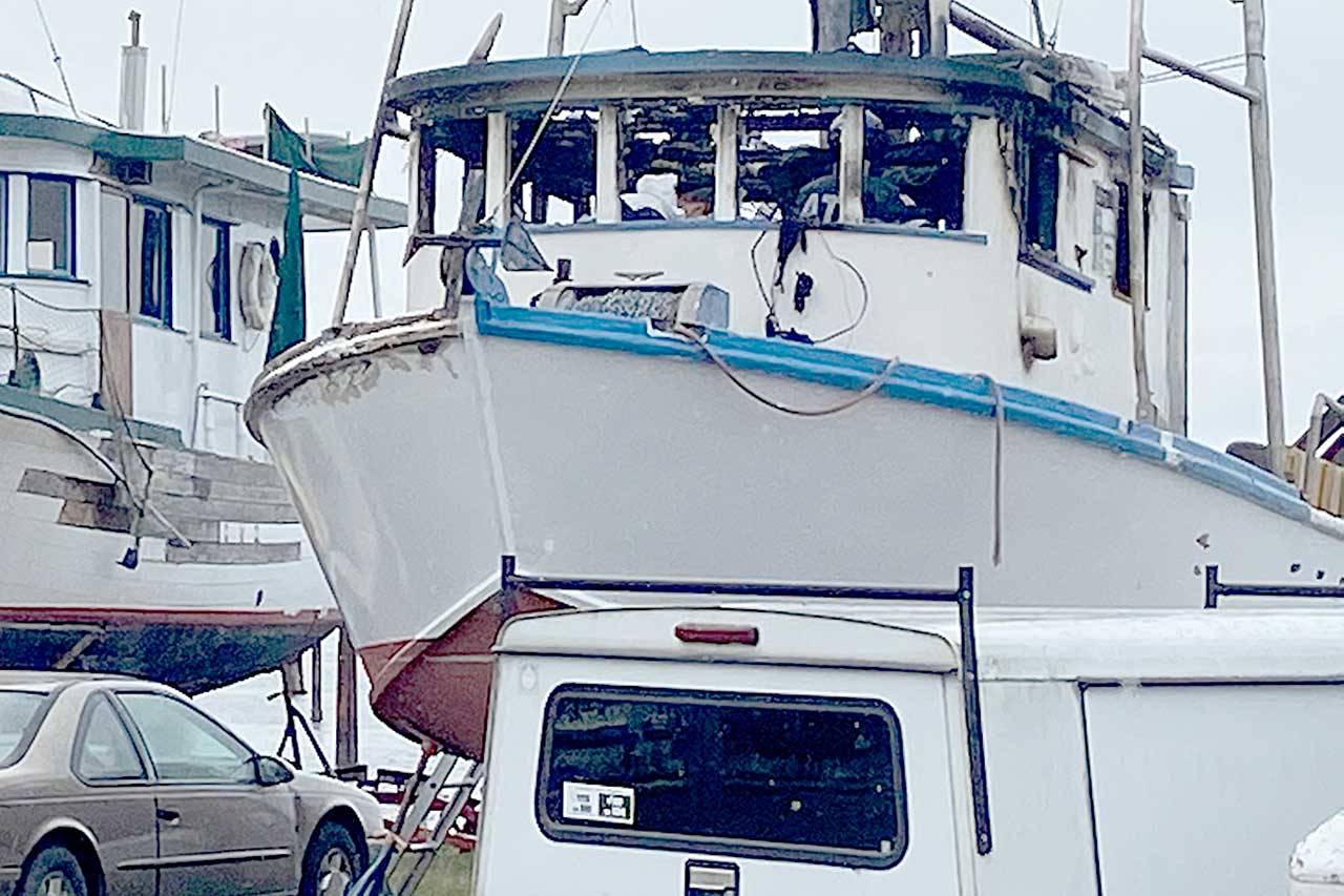 Port Angeles police and the federal Bureau of Alcohol, Tobacco, Firearms and Explosives investigators search the wheelhouse of the Karen L on Sunday. A man was found dead inside the fishing vessel after a fire early Sunday, police said. (Rob Ollikainen/Peninsula Daily News)
