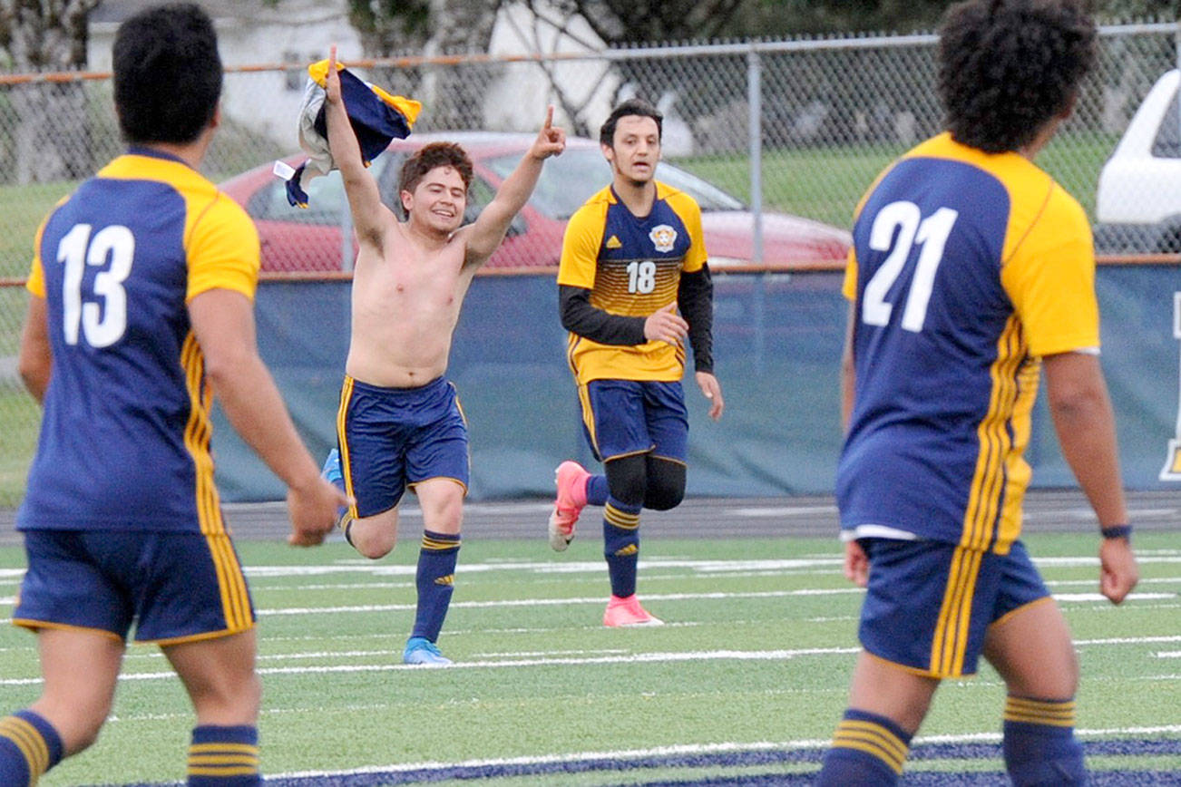 Forks' Juan Pablo Flores waves his jersey in celebration after scoring the first goal against Columbia Adventist during this playoff contest at Spartan Stadium in Forks Tuesday evening.  Also pictured are Andres Santos (13) Aristeo Ayala-Weed (18) and Luis Perez (21). (Lonnie Archibald/for the Peninsula Daily News)