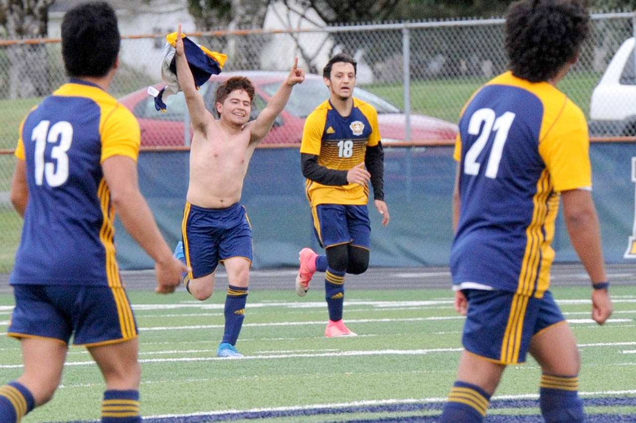 Forks’ Juan Pablo Flores waves his jersey in celebration after scoring the first goal against Columbia Adventist during this playoff contest at Spartan Stadium in Forks Tuesday evening. Also pictured are Andres Santos (13) Aristeo Ayala-Weed (18) and Luis Perez (21). (Lonnie Archibald/for the Peninsula Daily News)