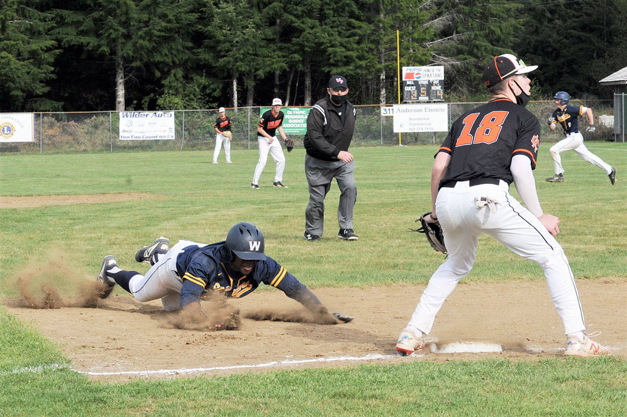 Forks’ Trey Baysinger slides into third while in the background Riley Pursley heads for second during a successful double steal against Kalama. The Spartans edged the Chinooks 4-3 to advance to the district championship.
Lonnie Archibald/for Peninsula Daily News