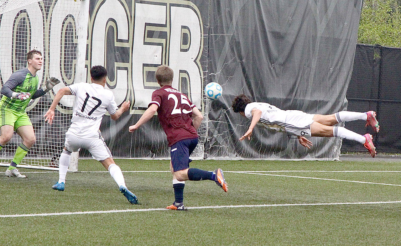 Peninsula Colleges Nico Hernandez heads in a goal against Whatcom on Monday afternoon. In on the play is Peninsulas Fernando Tavares (17). (Dave Logan/for Peninsula Daily News)