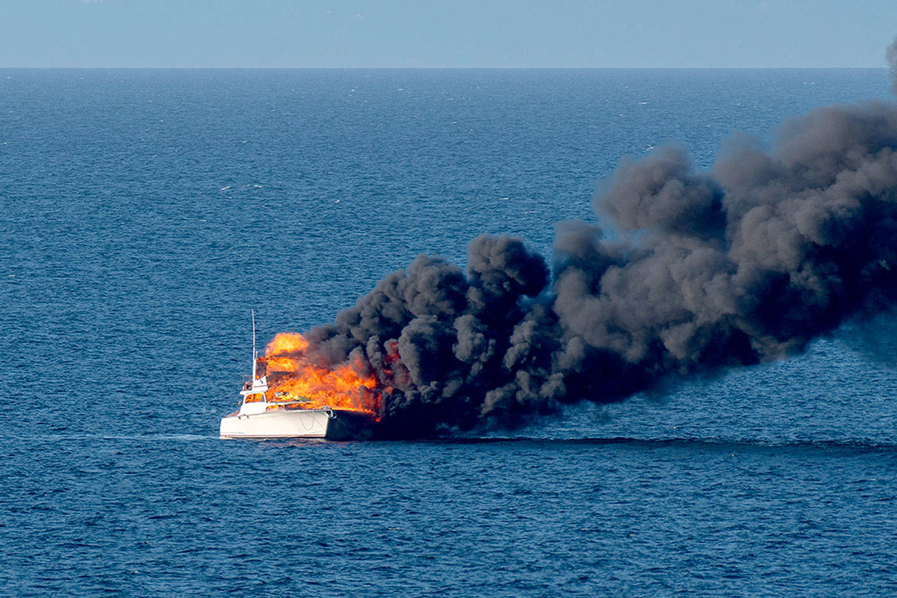 A 48-foot fishing yacht burns in the Strait of Juan de Fuca in this photograph captured by Port Angeles resident Ken Campbell.