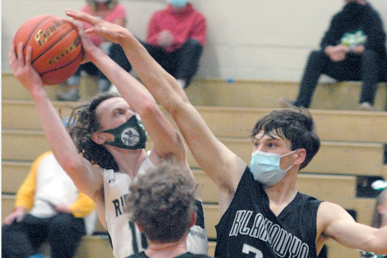 Keith Thorpe/Peninsula Daily News
Port Angeles' Dru Clark, left, looks for the hoop while fending off Klahowya's Drew Craft, right and Damon Clarke in the second half on Thursday at Port Angeles High School.
