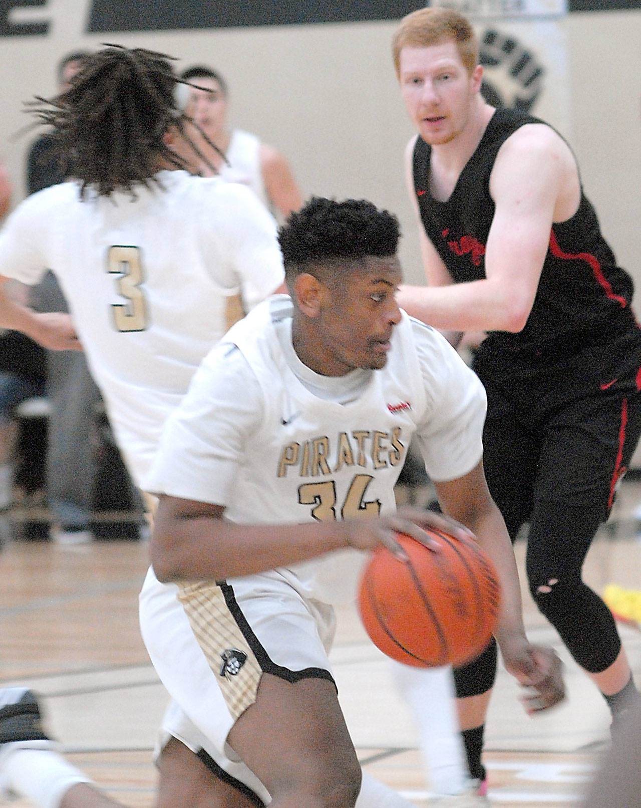 Keith Thorpe/Peninsula Daily News Peninsula’s Isiah Sampson, center, receives a block from teammate Jaylin Reed, left, to evade the defense of Everett’s Devin Smith on Friday in Port Angeles.