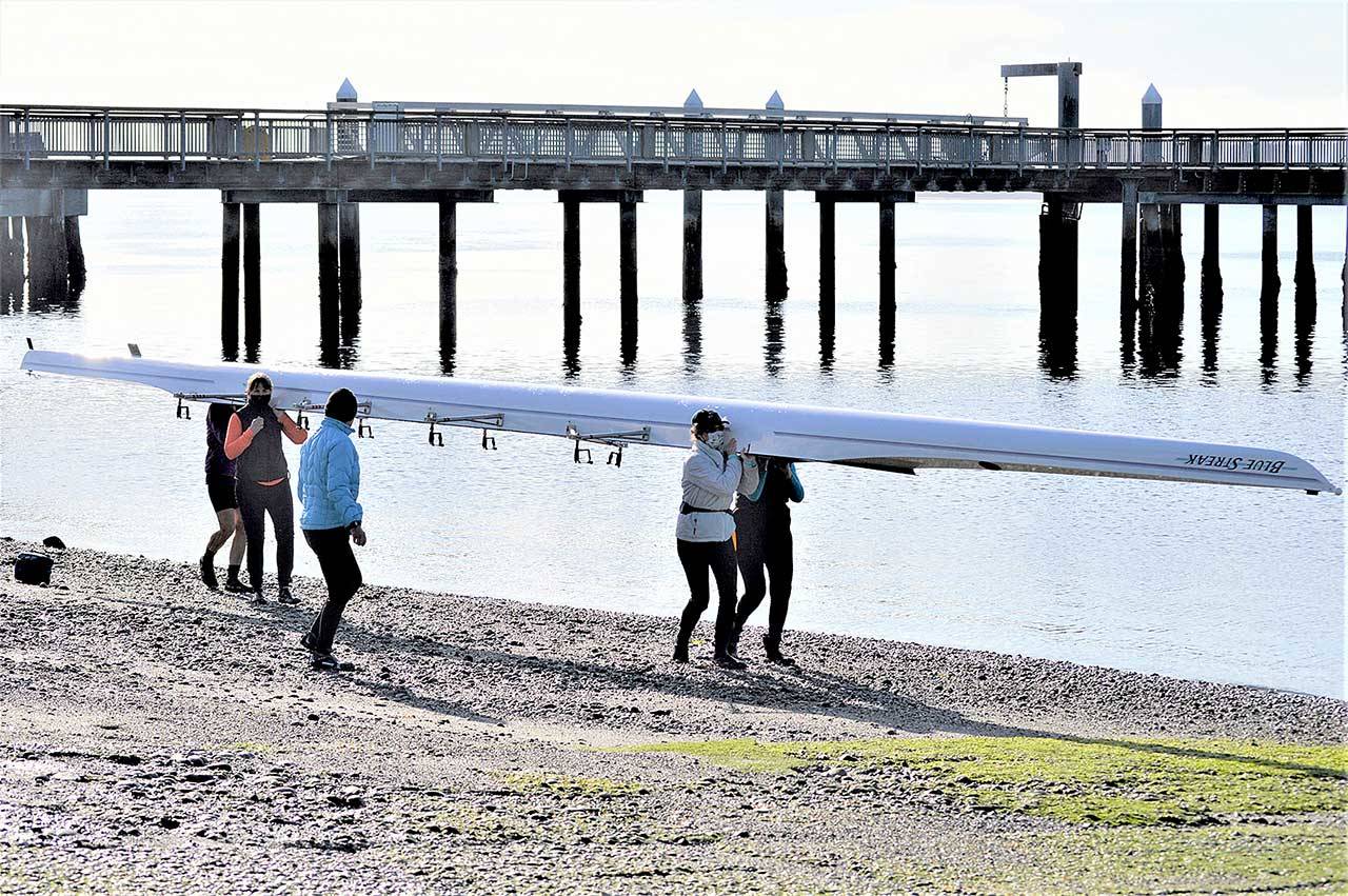 For the first time in a year, the Tuff as Nails rowing team took the Blue Streak for a sun-splashed spin in Port Townsend Bay on Monday morning. Coming back in are Nikki Russell, facing front at left, Barb Hager and Christine Edwards; on the other side of the boat are Mari Friend and Zoe Ann Dudley. (Diane Urbani de la Paz/Peninsula Daily News)
