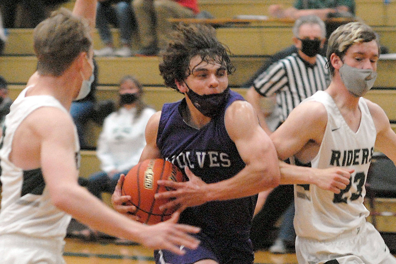 Keith Thorpe/Peninsula Daily News
Sequim's Tyler Mooney, center, drives to the lane flanked by Port Angeles' Tanner Price, left, and Michael Soule on Wednesday night in Port Angeles.