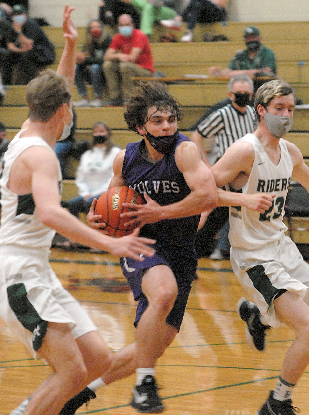 Sequims Tyler Mooney, center, drives to the lane flanked by Port Angeles Tanner Price, left, and Michael Soule on Wednesday night in Port Angeles. (Keith Thorpe/Peninsula Daily News)