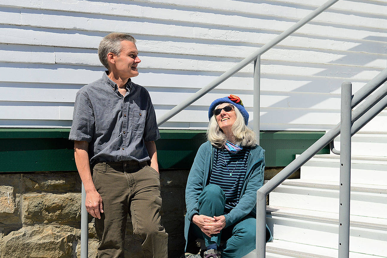 KPTZ-FM board president Robert Ambrose and general manager Kate Ingram take in the sun outside the radio station's new quarters at Fort Worden. The community station will move from Port Townsend's Mountain View Commons to the 2,500-square-foot Building 305 this summer. (Diane Urbani de la Paz/Peninsula Daily News)