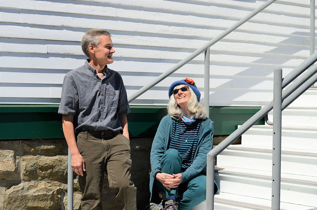 KPTZ-FM board president Robert Ambrose and general manager Kate Ingram take in the sun outside the radio station’s new quarters at Fort Worden. The community station will move from Port Townsend’s Mountain View Commons to the 2,500-square-foot Building 305 this summer. (Diane Urbani de la Paz/Peninsula Daily News)