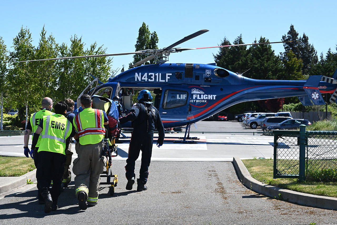 Personnel with Life Flight Network, Olympic Ambulance and Clallam County Fire District 3 secure a patient for transport Friday morning from a helipad in Sequim. The 69-year-old Port Angeles man was injured in a single car roll-over on U.S. Highway 101. (Michael Dashiell/Olympic Peninsula News Group)