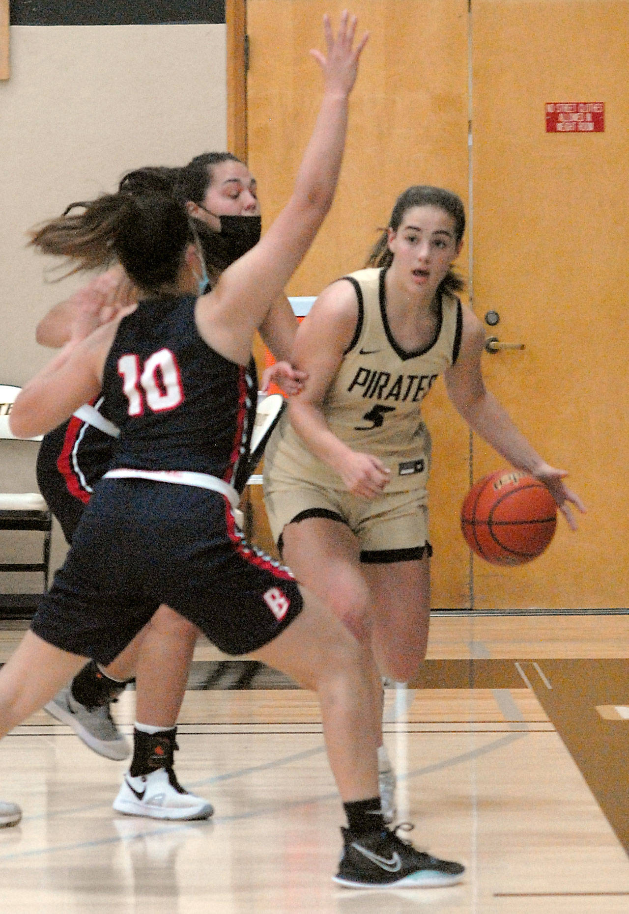 Peninsula’s Hope Glasser, a graduate of Sequim High School, right, fends off the defense of Bellevue’s Mo Bungay, front, and Mckayla Rodriguez on Saturday in Port Angeles. (Keith Thorpe/Peninsula Daily News)