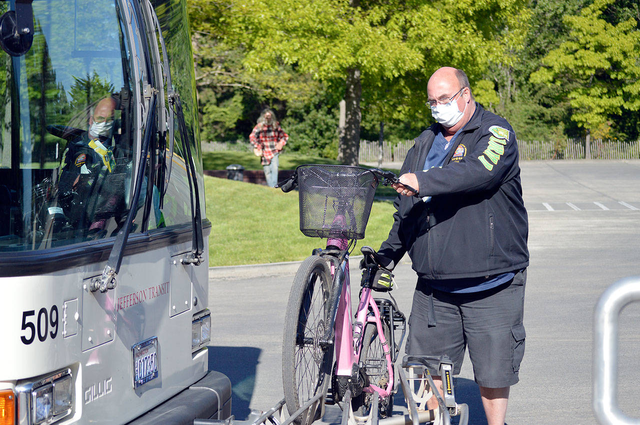 Jefferson Transit driver Lloyd Eisenman loads an electric bicycle onto the rack of the Sequim-bound bus Friday at the Haines Place transit center in Port Townsend. Heavy e-bikes must ride in the rack position closest to the bus’ bumper to avoid stressing the rack. (Diane Urbani de la Paz/Peninsula Daily News)