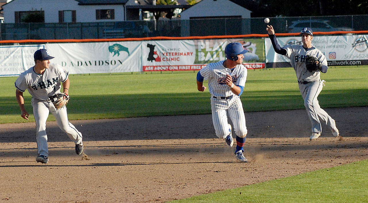 Lefties’ Damiano Palmegani, center, gets caught in a rundown between second and third as Bellingham second baseman Mason Margenco, left, looks at the toss from shortstop Collin Burns in the bottom of the third in June 2019 at Port Angeles Civic Field. Palmegani was forced out on the play. (Keith Thorpe/Peninsula Daily News)