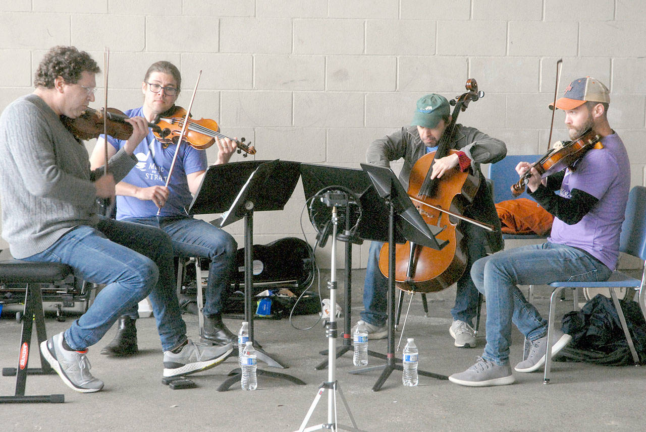 Giving an outdoor concert at Dry Creek Elementary School in Port Angeles are, from left, Noah Geller, James Garlick, Efe Baltacigil and David Auerbach. The musicians came from Seattle, Minnesota and Port Angeles. (Keith Thorpe/Peninsula Daily News)