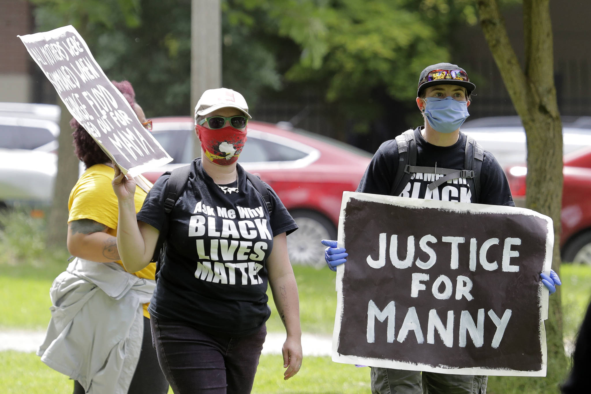 FILE - A protester holds a sign that reads "Justice for Manny" in this June 5, 2020 file photo in Tacoma, Wash., during a protest against police brutality. On Thursday, May 27, 2021, the Washington state attorney general filed criminal charges against three police officers in the death of Manuel Ellis, a Black man who died after telling the Tacoma officers who were restraining him he couldn't breathe. (AP Photo/Ted S. Warren, File)