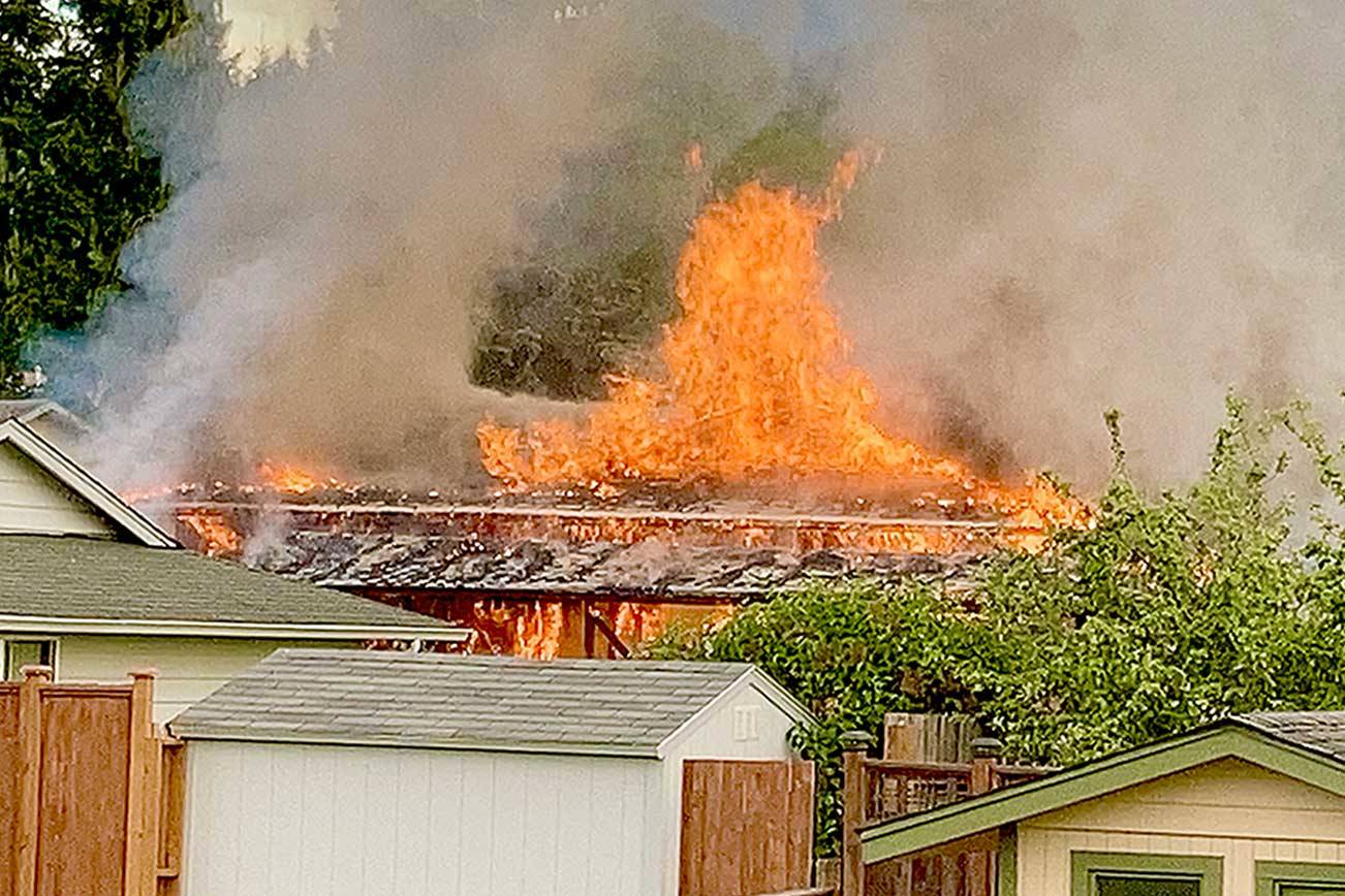 Flames shoot from the roof of a house on East Hawthorne Place on Sunday. Port Angeles Fire Department crews responded and knocked down the majority of the blaze within 10 minutes of arrival.