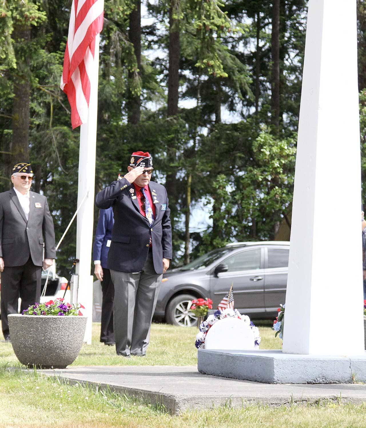 Navy veteran Rod Lee salutes a wreath he presented Monday representing VFW of Carlsborg at Sequim View Cemetery. About 100 people gathered for the short ceremony on Memorial Day to remember those who gave the ultimate sacrifice. (Dave Logan/for Peninsula Daily News)
