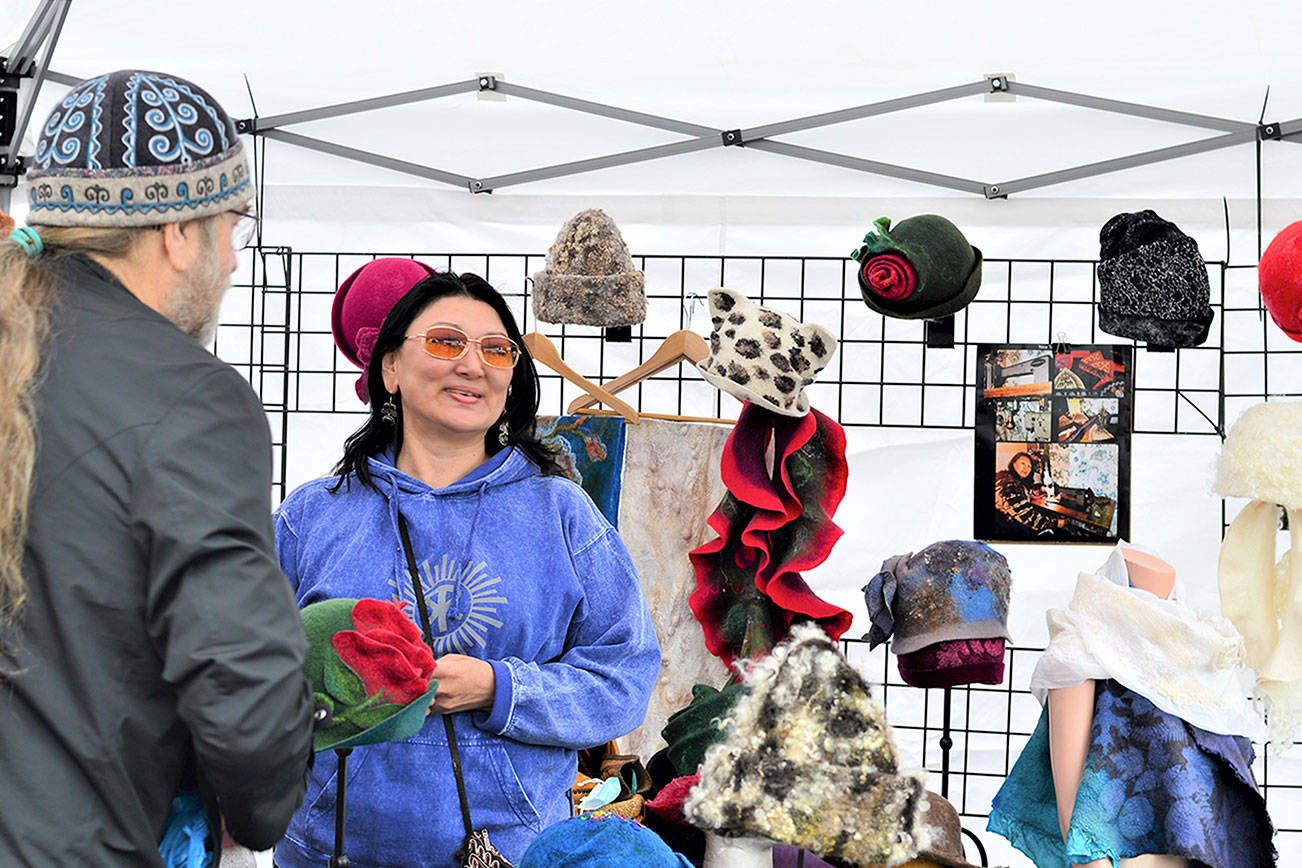 Shawn Woodyard of Port Angeles talks with Juan de Fuca Festival street fair vendor Cholpon Djumabaeva, who with her husband Jon runs Kyrgyz-Konnection of Gig Harbor. Diane Urbani de la Paz/Peninsula Daily News