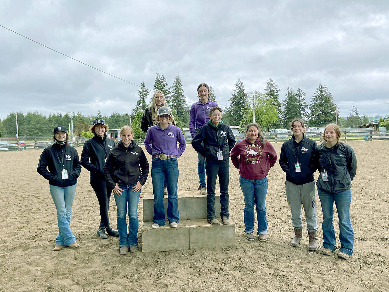 Sequim and Port Angeles high school equestrian teams take a break at the Washington High School Equestrian Team District 4s third and final meet in Elma before state finals. They are bottom row, from left, Haley Bishop (PA), Katie Marchant (PA), Libby Swanberg (S), Keri Tucker (S), Sydney Hutton (PA), Abby Garcia (S), Sara Holland (PA) and Amelia Kinney (PA); top row, from left, Susannah Sharp (S) and Rainey Bronsink (S). (Photo courtesy of Katie Newton)
