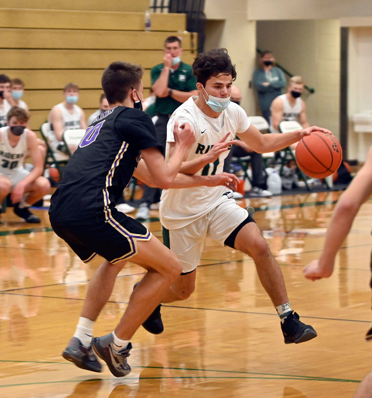 Michael Dashiell/Olympic Peninsula News Group Port Angeles’ Xander Maestas drives while defended by North Kitsap’s Cade Orness during the Riders’ 75-65 Olympic League Championship loss Wednesday. Maestas scored a game-high 28 points.